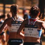 Two women athletes competing in a marathon with blurred background for dynamic effect.